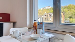 Ein Essbereich mit einem Tisch für zwei, einer Saftflasche und einer Müslischachtel.