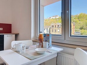 A dining area with a table set for two, a bottle of juice, and a box of cereal. - Cozy Home Lahnstein by Interhome (Lahnstein (Koblenz))