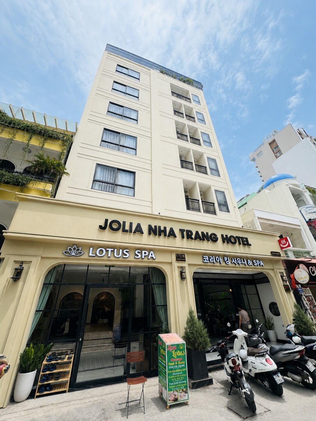 A hotel with a spa named Lotus SPA, featuring a modern facade, a visible entrance, and a signboard for Lotus SPA.