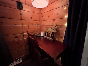 A wooden room with a table, chair, and a decorative moose head.
