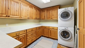 A kitchen with wooden cabinets, a double washer, and a patterned rug. - Secluded Mountain Ranch Home on 217 acres | Views | Fireplace | Hot Tub | Trout Pond (Silt)