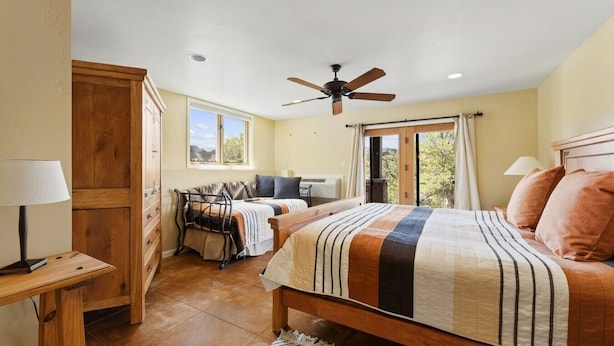 A bedroom with a bed, a desk, a chair, a ceiling fan, and a window. - Secluded Mountain Ranch Home on 217 acres | Views | Fireplace | Hot Tub | Trout Pond (Silt)