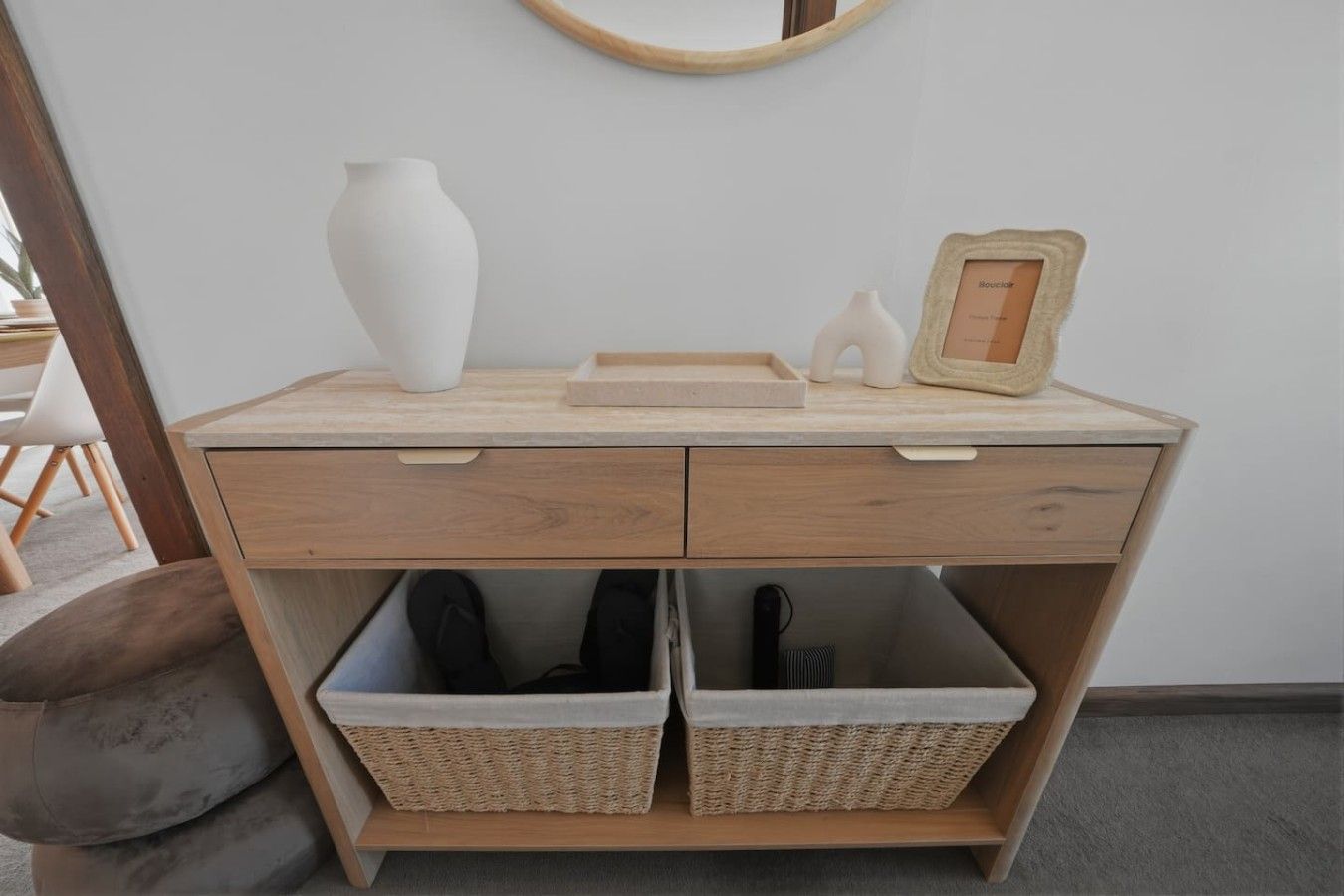 Ein Holztisch mit zwei Schubladen und zwei Korbüben darunter.