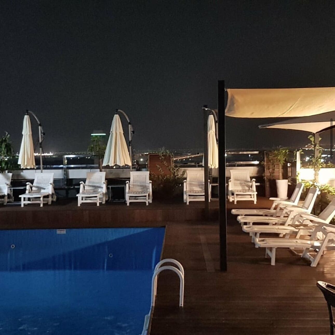 Una piscina al aire libre de temporada, sombrillas, tumbonas