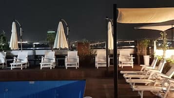 Una piscina al aire libre de temporada, sombrillas, tumbonas