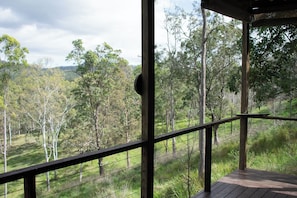 A wooden deck with a view of a forested area.