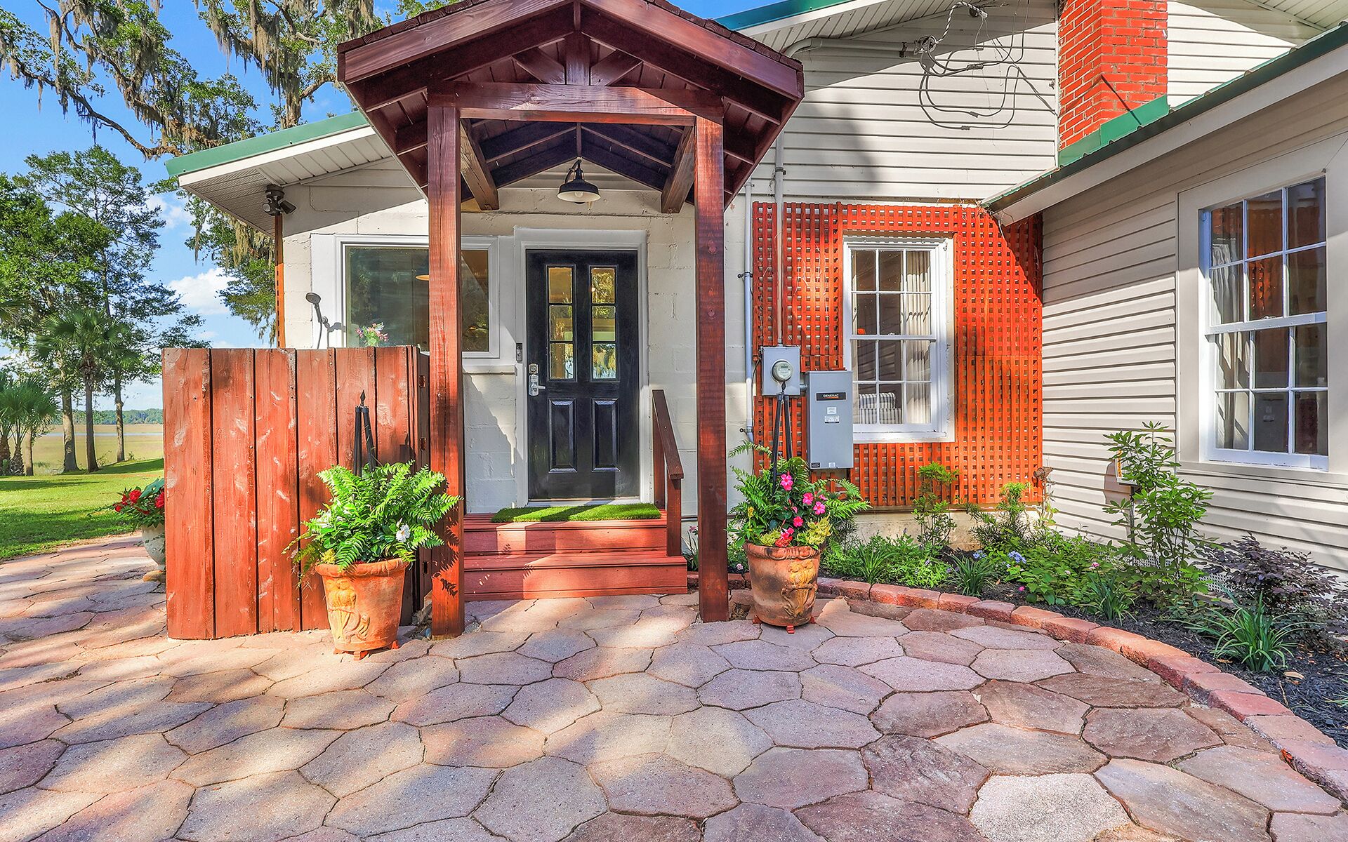 A house with a covered porch, a front door, and a brick chimney.
