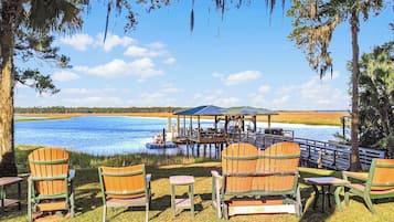 Une terrasse au bord du lac, avec des chaises et un belvédère offrant une vue sur l’eau.