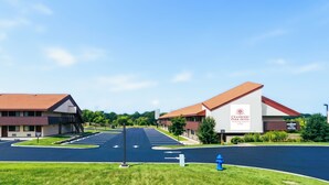 Un hôtel doté d’un parking, un bâtiment avec un toit rouge et une enseigne indiquant « Cranberry Park Hotel ».