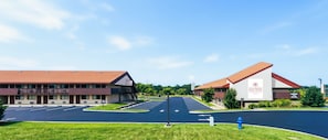 A hotel with a parking lot, a building with a red roof, and a sign for Cranberry Park Hotel. - CRANBERRY PARK HOTEL  (Cranberry Township)