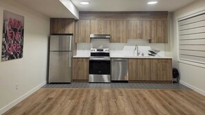 Una cocina moderna con armarios de madera, electrodomésticos de acero inoxidable y salpicadero de azulejos.