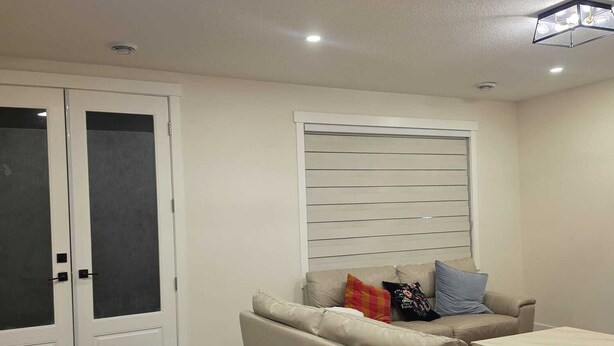 Una sala de estar con un sofá, una mesa de centro y una ventana con persianas.