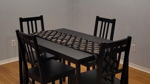 Ein Esszimmer mit einer Deckenleuchte, einem Holztisch und Stühlen.