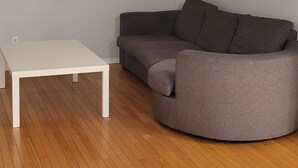 Ein Wohnzimmer mit einem weißen Couchtisch und einem grauen Sofa.