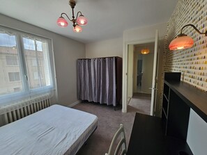 Une chambre comprenant un lit, une armoire, un bureau et un espace douche.