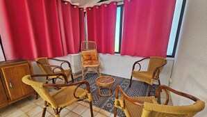 A room with four wicker chairs, a small round table, and a cabinet. - House for 1–8 people, garden, 10 minutes from Futuroscope and downtown, French “ 1965-1970 ” decor (Poitiers)