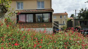 A residential building with a brick facade, large windows, and a tiled roof. - House for 1–8 people, garden, 10 minutes from Futuroscope and downtown, French “ 1965-1970 ” decor (Poitiers)