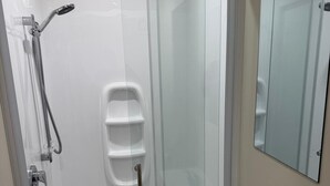 A modern bathroom with a glass-enclosed shower, a white sink, and a mirror.