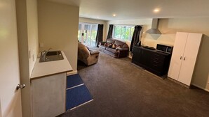 A compact living space with a kitchenette, a sofa, and a dining area.