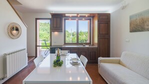Una cocina moderna con una mesa de comedor, un sofá y vistas a zonas verdes.