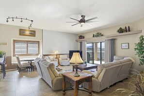 A spacious living room with a sofa set, a dining table, and a ceiling fan. - Villa Palmas - Pool, Comfort, Parking, ProjectorTV (Lake Havasu City)