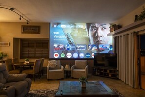 Un salon doté d’un grand téléviseur à écran plat, de sièges confortables et d’une cheminée.