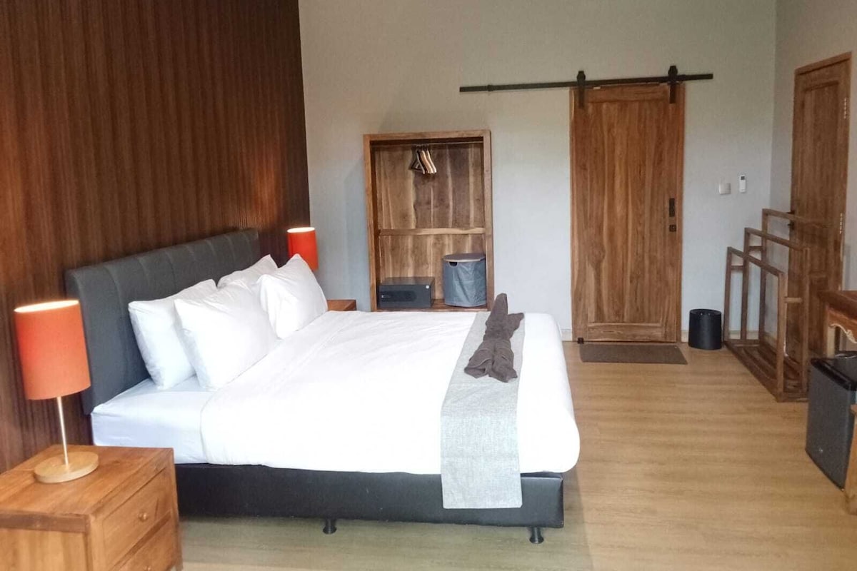 Un dormitorio con cama, mesitas de noche, un armario y una puerta corredera.