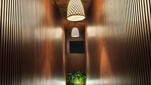 A corridor with wooden paneling and a hanging pendant light. - Home Dejavu (Gili Trawangan)