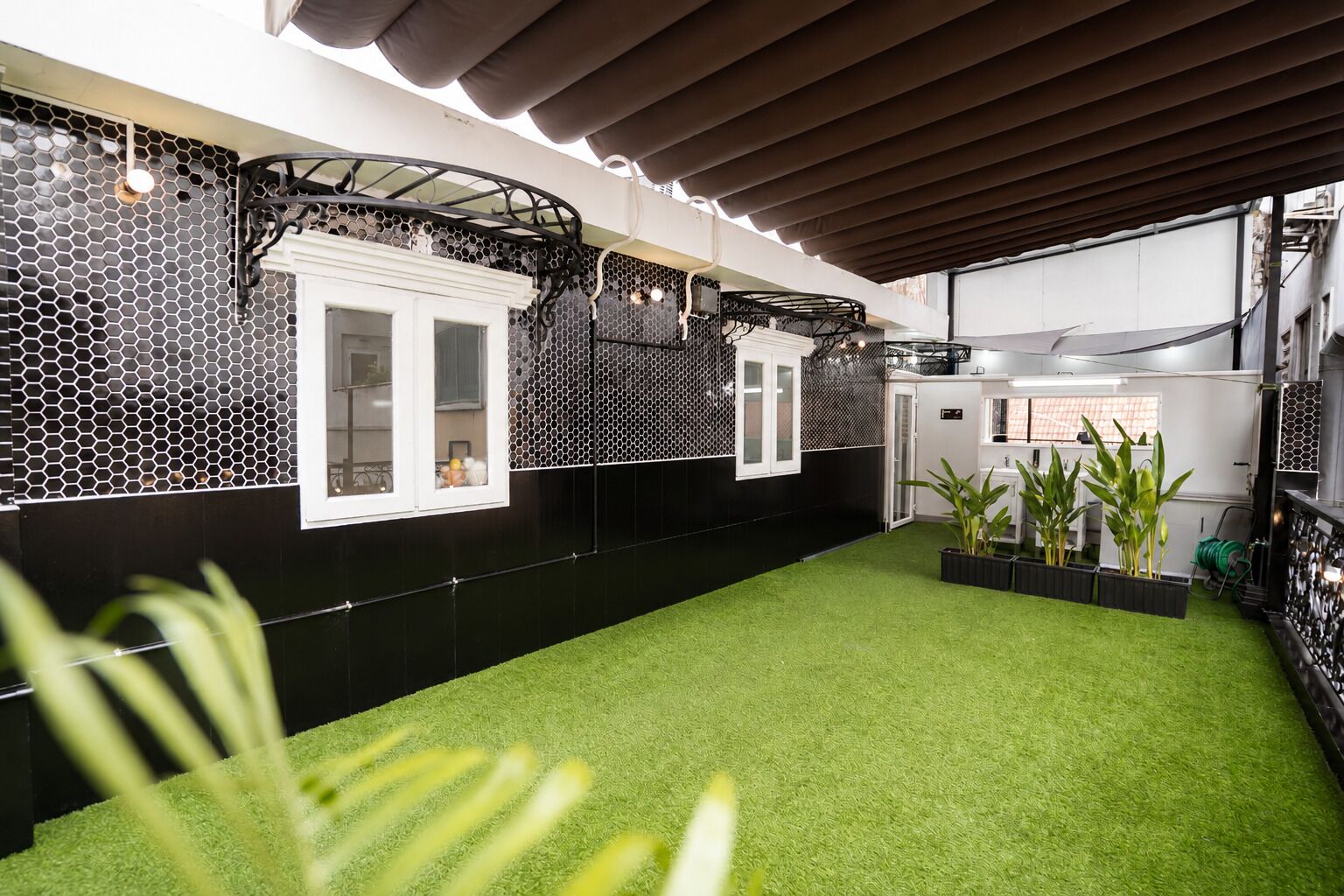 Una cocina moderna con baldosas hexagonales blanco y negro, armarios blancos y piso de césped artificial verde.
