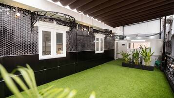 Una cocina moderna con baldosas hexagonales blanco y negro, armarios blancos y piso de césped artificial verde.