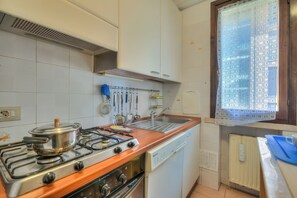 Een keuken met een fornuis, spoelbak en vaatwasser.