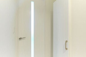 A closed door with a simple handle and a light switch on the wall. - Fontaine Kamata by Tranova 2 (Ota City)