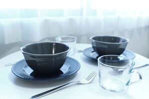 A table with a set of bowls, a glass, and a fork on a white tablecloth. - Fontaine Kamata by Tranova 2 (Ota City)