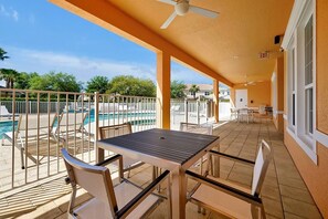 Un espace extérieur abrité comprenant une piscine, des chaises et une table.