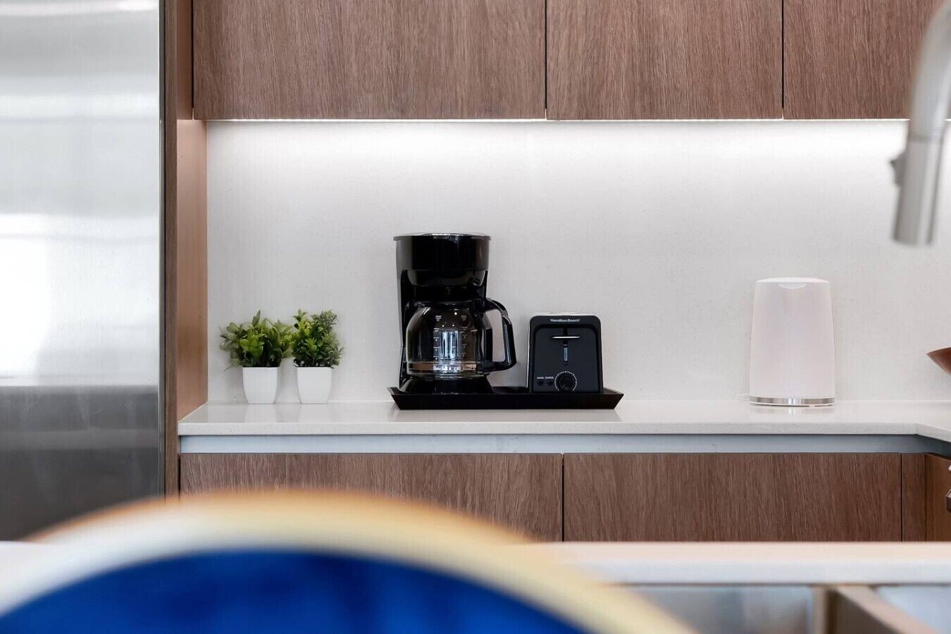 Eine moderne Küche mit Kaffeemaschine, Waage und einem Glas Wasser auf der Arbeitsfläche.