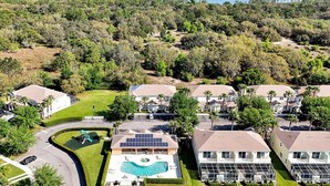 Un quartiere residenziale con case, una piscina e un lago sullo sfondo.