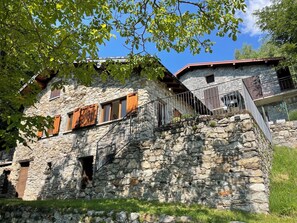 Un bâtiment en pierre avec un escalier en bois menant à un balcon.