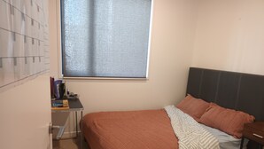 Une chambre à coucher avec un lit, un bureau et une fenêtre.