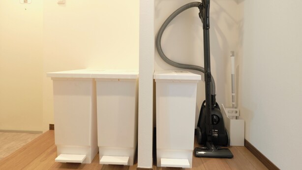 A hallway with a vacuum cleaner, a white wall, and a wooden floor. - Fuente Nishi Sugamo by Tranova 2 (Toshima)