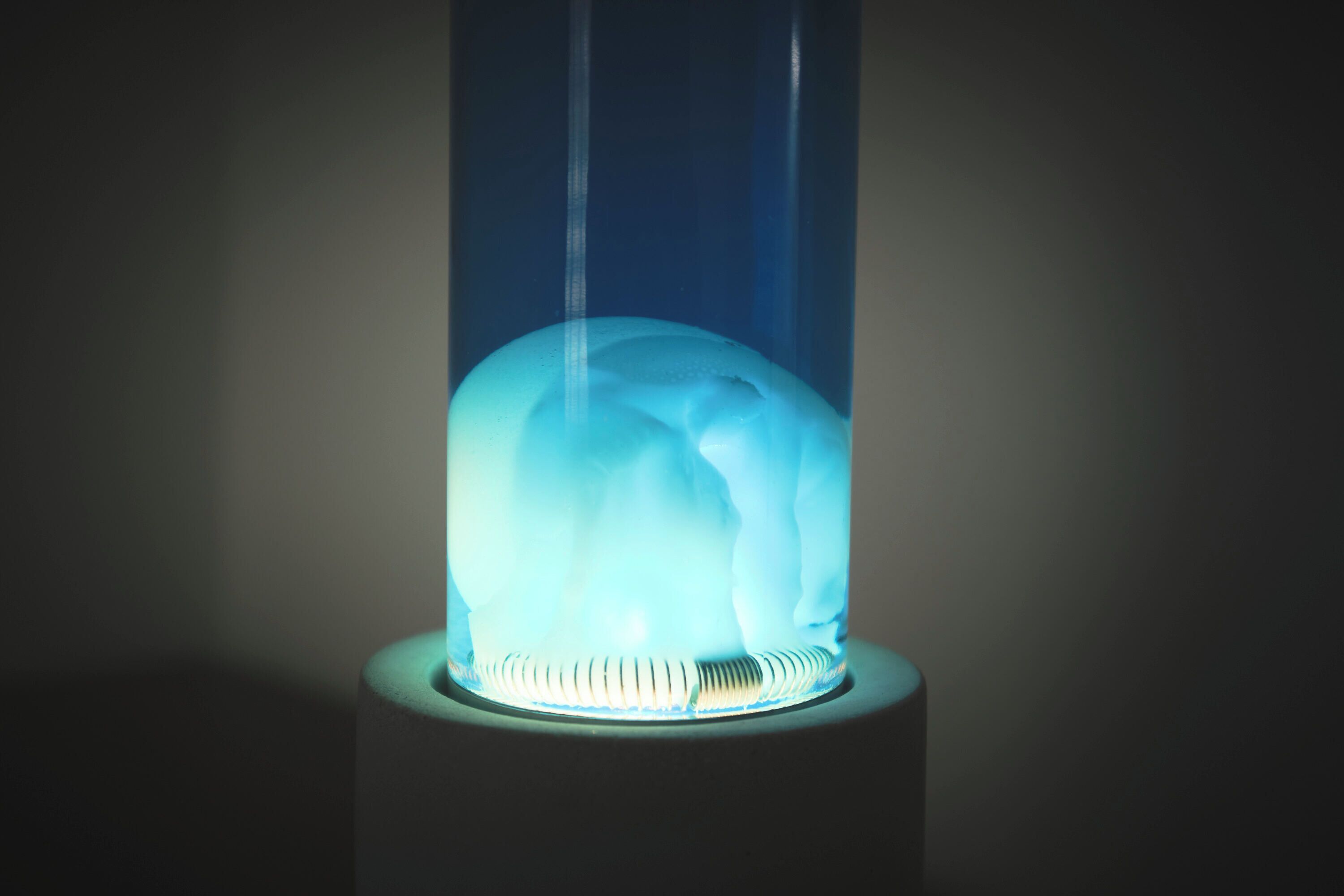 Un objeto cilíndrico con un interior azul brillante, posiblemente una lámpara o un adorno.