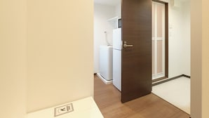 Une pièce avec une porte en bois, un radiateur blanc et un appareil électroménager blanc en arrière-plan.