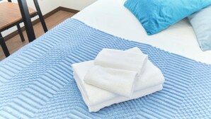 A bed with a blue textured blanket, a white pillow, and a blue pillow. - Fuente Nishi Sugamo by Tranova 2 (Toshima)