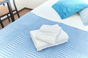 A bed with a blue textured blanket, a white pillow, and a blue pillow. - Fuente Nishi Sugamo by Tranova 2 (Toshima)