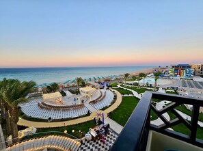 Ein Resort mit Pool, Strand und einer runden Sitzgelegenheit im Freien.