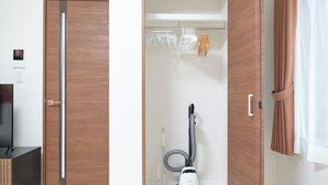 A room with a wooden door, a vacuum cleaner, a towel rack, and a curtain. - GRANQUAL Horikiri by Tranova 2 (Adachi)
