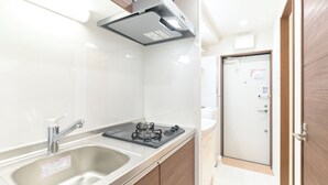 A modern kitchen with stainless steel appliances, a sink, and wooden cabinets. - GRANQUAL Horikiri by Tranova 2 (Adachi)