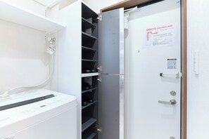 Ein Zimmer mit einem weißen Heizkörper, einem Metallschrank mit Regalen und einer Tür mit einem Evakuierungswegschild.