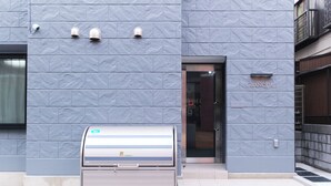 A building facade with a textured blue wall, a door labeled "GRANQUAL," and a mail slot. - GRANQUAL Horikiri by Tranova 2 (Adachi)
