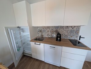 A compact kitchen with white cabinets, a coffee maker, and a dishwasher. - Apartment with sea-facing terrace and swimming pool (Saint-Cyprien)