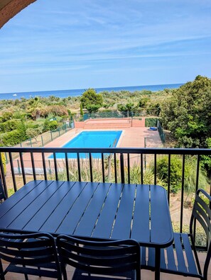 A pool with a view of the sea, surrounded by greenery. - Apartment with sea-facing terrace and swimming pool (Saint-Cyprien)